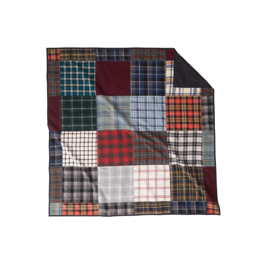 Nice Blanket Signature Memory Quilt made from plaid shirts in a mix of navy, red, green, gray, black, and white patterns in a 16 square grid, with a black backing folded over at the upper right corner.