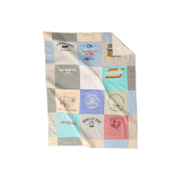 Nice Blanket Signature Memory Quilt made from travel-themed shirts in a 12 square grid in soft blue, ivory, gray, aqua, lavender, and coral, featuring destinations including Winter Park, Honolulu, East Hampton, Palm Springs, Maine, Panama City Beach, and other vacation memories.